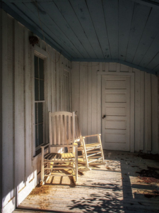Abandoned rocking chairs on screened porch of proprietors residence